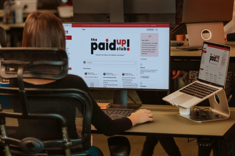 The Paid Up Club website presented on desktop and laptop screens
